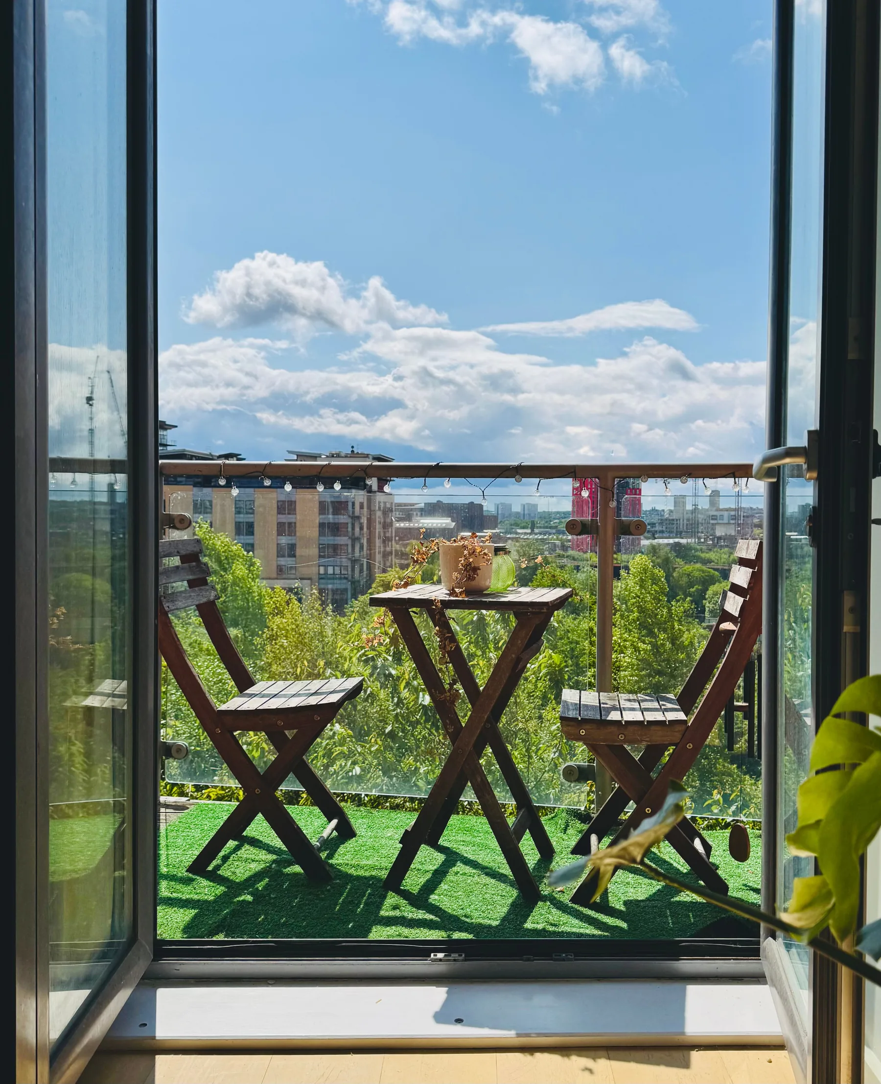 Apartment balcony with table, chairs and city view