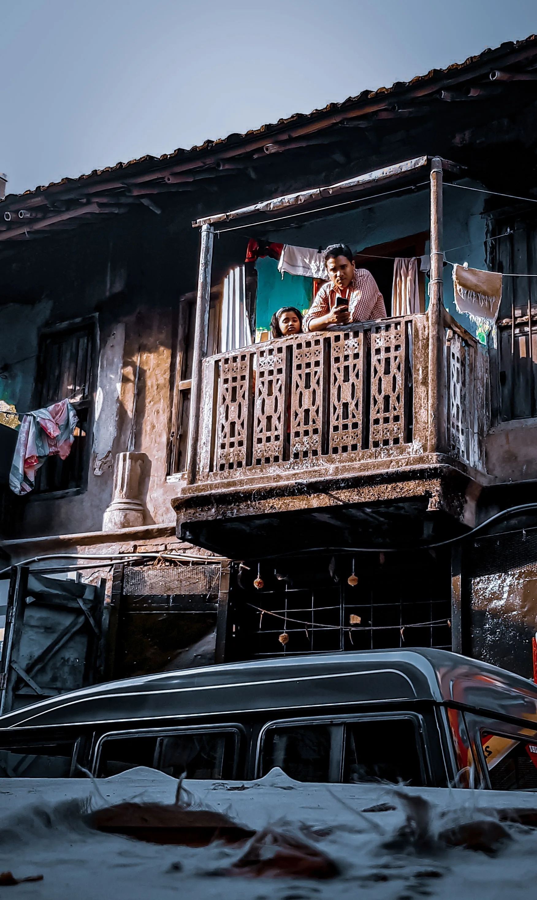Family standing at a residential balcony